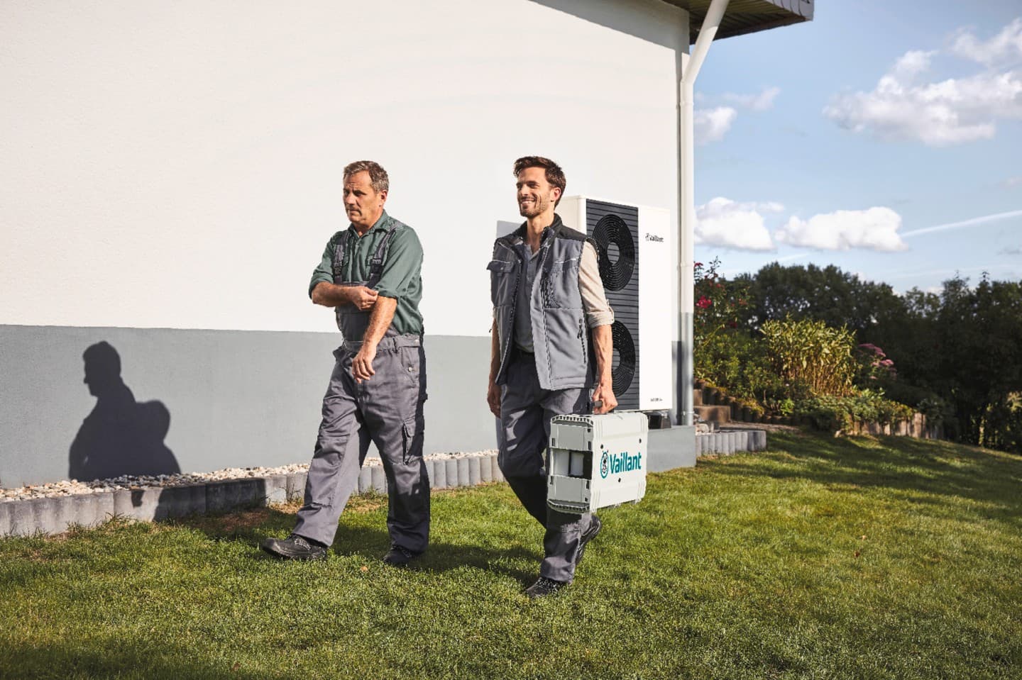 Professionnels Vaillant qui marchent dans le jardin d'un client